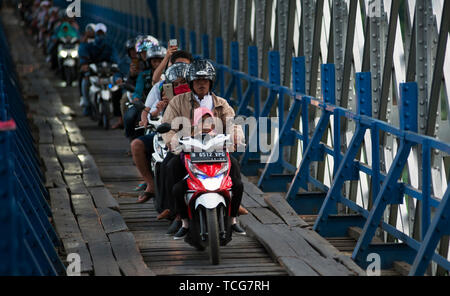 West Java, West Java. 8 Giugno, 2019. Moto pendolari passano attraverso un attraversamento in legno sotto il Cirohang ponte ferroviario in Ciamis, West Java, Indonesia il 8 giugno 2019. Credito: Reza Estily/Xinhua/Alamy Live News Foto Stock