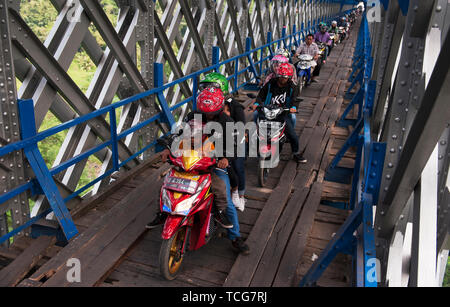 West Java, West Java. 8 Giugno, 2019. Moto pendolari passano attraverso un attraversamento in legno sotto il Cirohang ponte ferroviario in Ciamis, West Java, Indonesia il 8 giugno 2019. Credito: Reza Estily/Xinhua/Alamy Live News Foto Stock