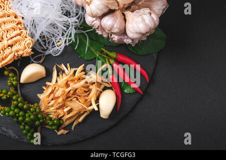 Vista dall'alto di ingredienti freschi. La cucina salutistica sfondo con verdura biologica per vegan su nero ardesia . Lo zenzero , Aglio , peperoncino fresco ed essiccato n Foto Stock