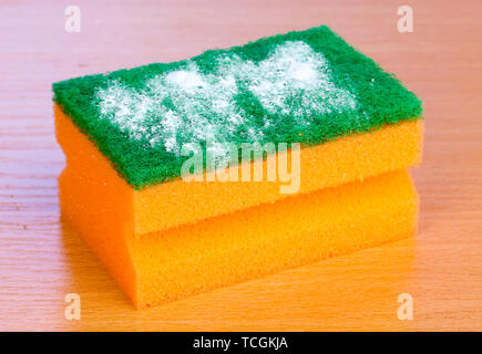 Spugna con polvere di lavaggio su un tavolo di legno su sfondo blu Foto  stock - Alamy