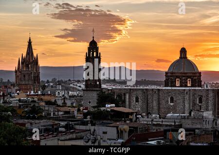 Tramonto sull'iconico chiese nel centro storico di San Miguel De Allende, Guanajuato, Messico. La Parroquia de San Miguel Arcangel, a sinistra la chiesa di San Francisco, a destra. Foto Stock