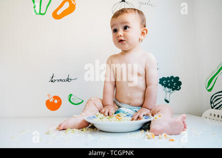Baby mangiare da lui stesso apprendimento attraverso il Baby-led metodo di svezzamento, esplorare i sapori degli alimenti con curiosità. Foto Stock