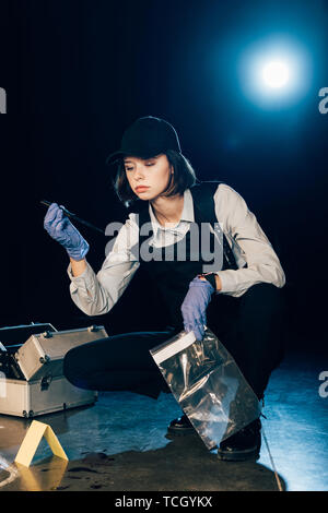 Sperimentatore tenendo il coltello e sacchetto ziploc alla scena del crimine Foto Stock