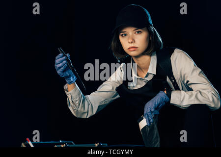 Sperimentatore in uniforme tenendo il coltello e sacchetto ziploc alla scena del crimine Foto Stock