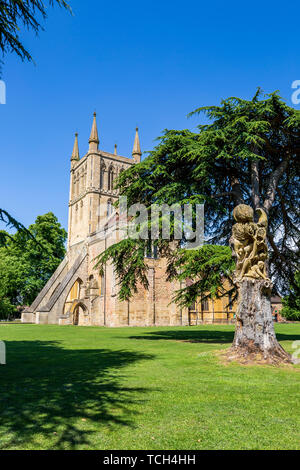 La chiesa di Pershore Abbey del 12 ° secolo con il Faggio albero Carving di Tom Harvey, Worcestershire, Inghilterra Foto Stock