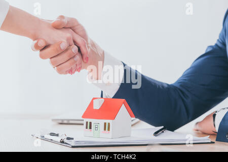 Vista parziale di realtor stringono le mani con il cliente vicino casa modello sul piano portapaziente Foto Stock