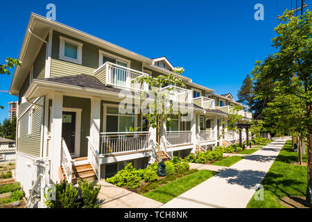 Nuovo di zecca townhouses con pavimentazione in calcestruzzo nella parte anteriore. Lato anteriore del case a schiera sulla giornata di sole in Canada Foto Stock