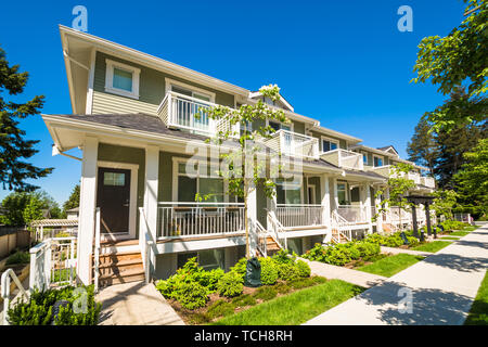 Nuovo di zecca townhouses con pavimentazione in calcestruzzo nella parte anteriore. Lato anteriore del case a schiera sulla giornata di sole in Canada. Foto Stock