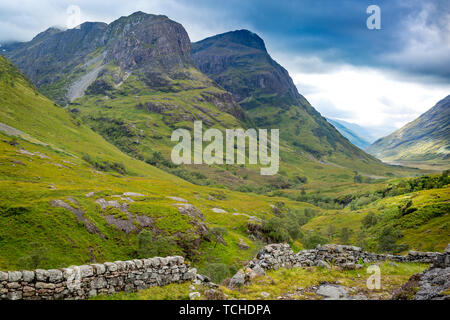 Muro di pietra e vista sulla valle sotto le montagne di Glencoe, Lochaber, altopiani, Scozia Foto Stock