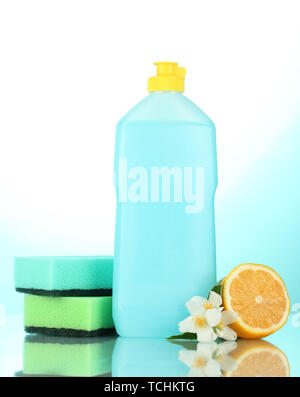 Detersivo liquido per stoviglie con spugne e limone con fiori su sfondo blu Foto Stock