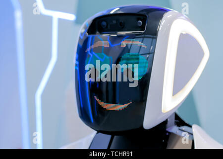 White timido robot con display a faccia in corrispondenza di mostra di robotica Foto Stock