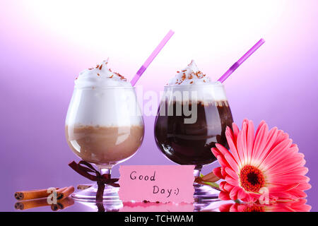 Bicchieri di caffè e cocktail di gerbera fiore su sfondo viola Foto Stock