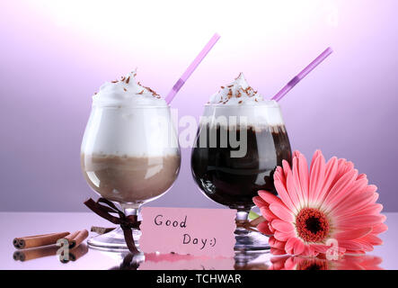 Bicchieri di caffè e cocktail di gerbera fiore su sfondo viola Foto Stock
