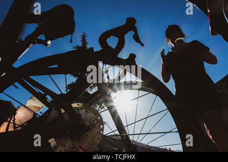 Pausa caffè - vacanza creativa immagine di un ciclista femmina riportando un caffè da un cafe in Spagna presa attraverso una bici con freni a disco Foto Stock