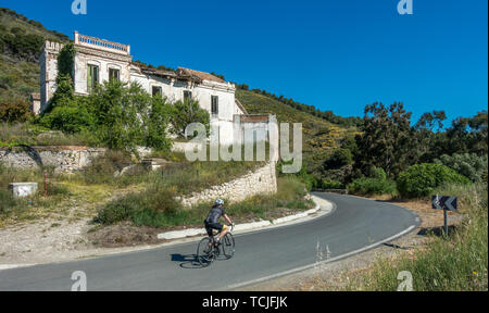 Ciclista passando un bellissimo vecchio rovinato mansion house sulla GR-4302 strada tra Guájar-Faragüit e Pinos del Valle, Sierra Nevada, Spagna Foto Stock