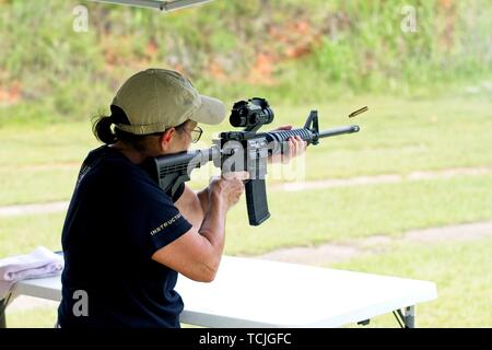 Una donna di sparare a un AR-15 fucile in corrispondenza di un poligono di tiro Foto Stock