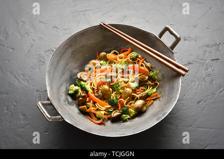 Udon friggere gli spaghetti con le verdure nel wok padella in pietra nera tabella. Vista ravvicinata Foto Stock