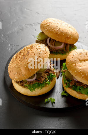 Tirato sandwich di manzo con verdure su tavola di legno nero su sfondo di pietra Foto Stock