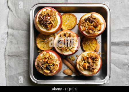 Red mele cotte con muesli, cannella, noci e miele su sfondo di pietra. Un sano dessert di frutta. Vista superiore piana e il cibo dei laici Foto Stock