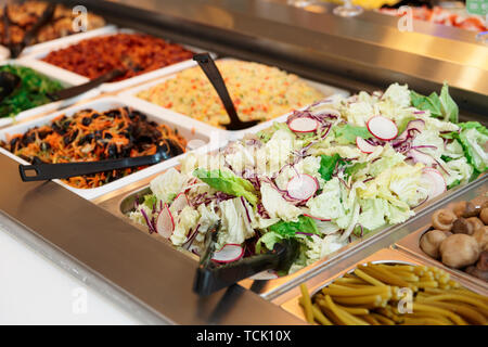 Vari tipi di insalate in contenitori gastronomiche, un negozio di alimentari o un ristorante Foto Stock