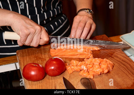 Lo chef femmina è il taglio di salmone con il Giapponese modello Yanagiba coltello Foto Stock