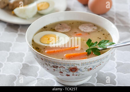 Tradizionale zuppa polacca Zurek con salsiccia bianca e uova. Foto Stock