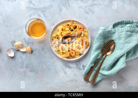 Piatti di pasta. Tagliolini con cozze, gamberi, vongole e anelli di totano, girato dalla parte superiore con un bicchiere di vino bianco e un posto per il testo Foto Stock