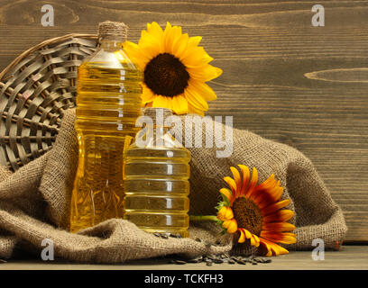 Olio in bottiglie, girasole e semi, su sfondo di legno Foto Stock