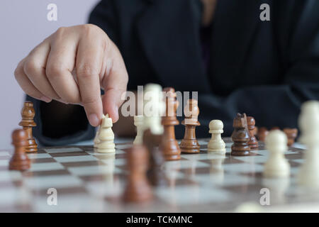 Immagine ravvicinata di mano business donna giocando la scacchiera da vincere per uccidere il re dell avversario metafora concorrenza Vincitore e Perdente sel Foto Stock