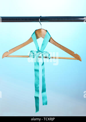Bellissimo il turchese bow appeso su appendiabiti in legno su sfondo blu Foto Stock