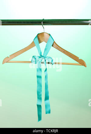 Bellissimo il turchese bow appeso su appendiabiti in legno su sfondo verde Foto Stock