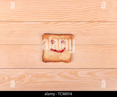 Fetta di pane con un sorriso su un di legno Foto Stock