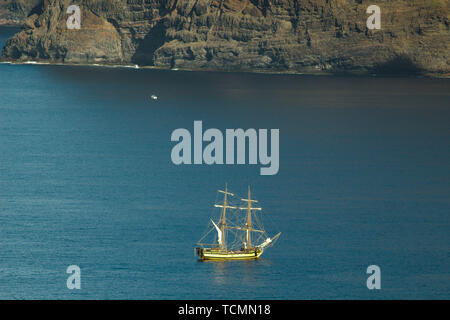 Yacht di turisti vicino le scogliere verticali Acantilados de Los Gigantes (Rupi dei Giganti). Vista dall'Oceano Atlantico. Foto Stock