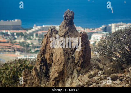 Grande mistica roccia lavica surraunded da canaria di piante endemiche. Los Cristianos vista da Guaza montagna. Tenerife, Isole Canarie. Spagna Foto Stock