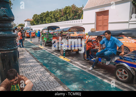 BANGKOK 7 FEBBRAIO 2016:triciclo taxi di Thailandia su strada e lo sfondo di Wat Phra Kaew ( il Tempio del Buddha di Smeraldo). Ecco le destinazioni Foto Stock