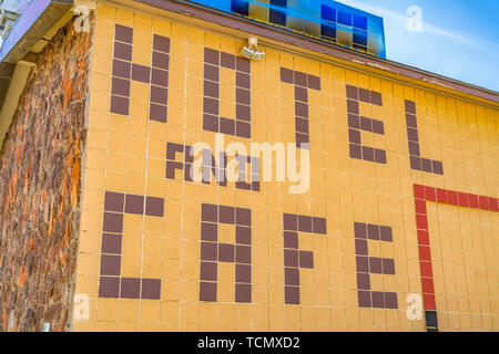 Hotel enorme e il Cafe segno sulla parete esterna di un edificio con luci esterne Foto Stock