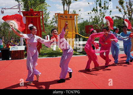 Pechino, Cina. Il 9 giugno, 2019. Attori eseguire Huagudeng, o fiore-tamburo opera, all'ingresso del giardino di Anhui durante l'Internazionale di Pechino mostra orticola in Yanqing District, Pechino, capitale della Cina, 9 giugno 2019. Anhui giorno evento a tema si è svolta durante il Beijing International Horticultural Mostra dal 9 Giugno al 11. Credito: Ju Huanzong/Xinhua/Alamy Live News Foto Stock