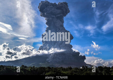 Karo, nel nord di Sumatra, Indonesia. Decimo Giugno, 2019. Il monte Sinabung durante l eruzione visto da Beganding villaggi Karo, nel nord di Sumatra il 9 giugno 2019. Sinabung scaricato 7000 metri di cenere vulcanica nel cielo, che ha rumbled dal 2010 ed è stato testimone di eruzioni mortale produca pelliccia folta dopo attività aumentata negli ultimi giorni. Credito: Albert Ivan Damanik/ZUMA filo/Alamy Live News Foto Stock