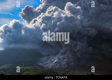 Karo, nel nord di Sumatra, Indonesia. Decimo Giugno, 2019.: mount Sinabung durante l eruzione visto dal villaggio Beganding. Sinabung scaricato 7000 metri di cenere vulcanica nel cielo, che ha rumbled dal 2010 ed è stato testimone di eruzioni mortale produca pelliccia folta dopo attività aumentata negli ultimi giorni. Credito: Albert Ivan Damanik/ZUMA filo/Alamy Live News Foto Stock