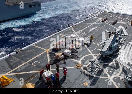 190531-N-NB544-1067 OCEANO PACIFICO (31 maggio 2019) Marinai e Marines gli approvvigionamenti per i trasporti sul ponte di volo del San Antonio-classe di trasporto anfibio dock nave USS John P. Murtha (LPD 26) durante un rifornimento verticale con il trasporto di carichi secchi e munizioni nave USNS Richard E. Byrd (T-AKE 4). John P. Murtha è attualmente sul suo maiden deployment e parte del Boxer anfibio gruppo pronto (ARG) e xi Marine Expeditionary Unit (MEU) team ed è distribuito per la 7a flotta area di operazione per sostenere la stabilità regionale, rassicurare partner ed alleati e mantenere una presenza postured per resp Foto Stock