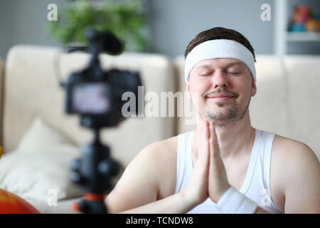 Giovane uomo Yoga Sport Registrazione Blog su telecamera Foto Stock