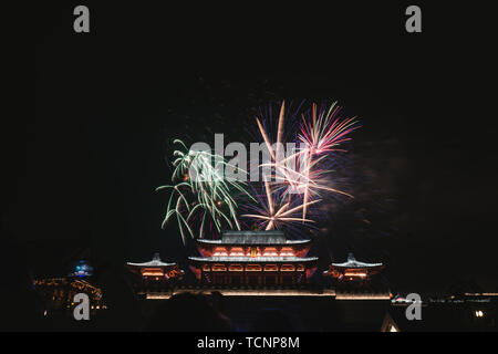 Fuochi d'artificio blooming cinese sopra gli antichi edifici Foto Stock