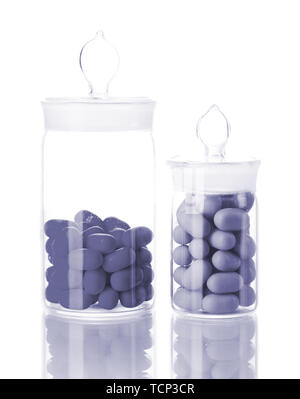 Bottiglie trasparenti con le pillole in luce grigia isolato su bianco Foto Stock
