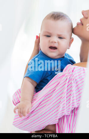 Foto della giovane madre è in possesso di un po' di piangere figlio Foto Stock