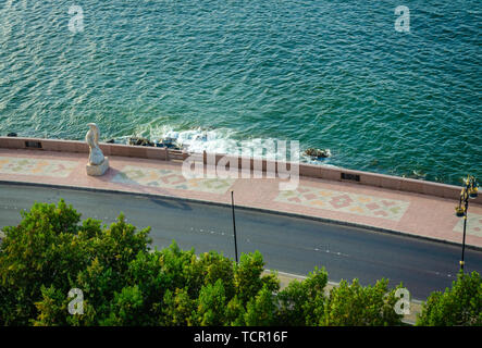 Strada costiera di pattern con pavimento piastrellato e un pesce statua da Muttrah, Muscat Oman. Foto Stock