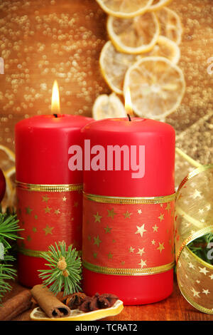 Due candele e decorazioni di Natale, su sfondo dorato Foto Stock