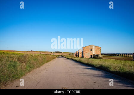 Il paesaggio agricolo della Murgia plateau con case coloniche abbandonate lungo la strada principale. Regione Puglia, Italia Foto Stock