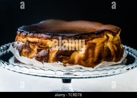 San Sebastian Cheesecake sulla torta di vetro piatto. / Pianura cremosa. Tradizionale stile di Spagna. Foto Stock