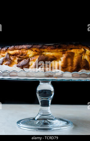 San Sebastian Cheesecake sulla torta di vetro piatto. / Pianura cremosa. Tradizionale stile di Spagna. Foto Stock