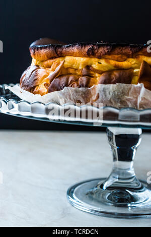 San Sebastian Cheesecake sulla torta di vetro piatto. / Pianura cremosa. Tradizionale stile di Spagna. Foto Stock